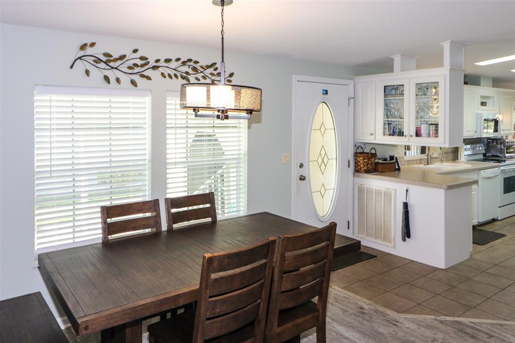 29200 South Jones Loop Road, Unit 522 Punta Gorda, FL 33950 - Photo 18 of 38 a kitchen with a table chairs and refrigerator
