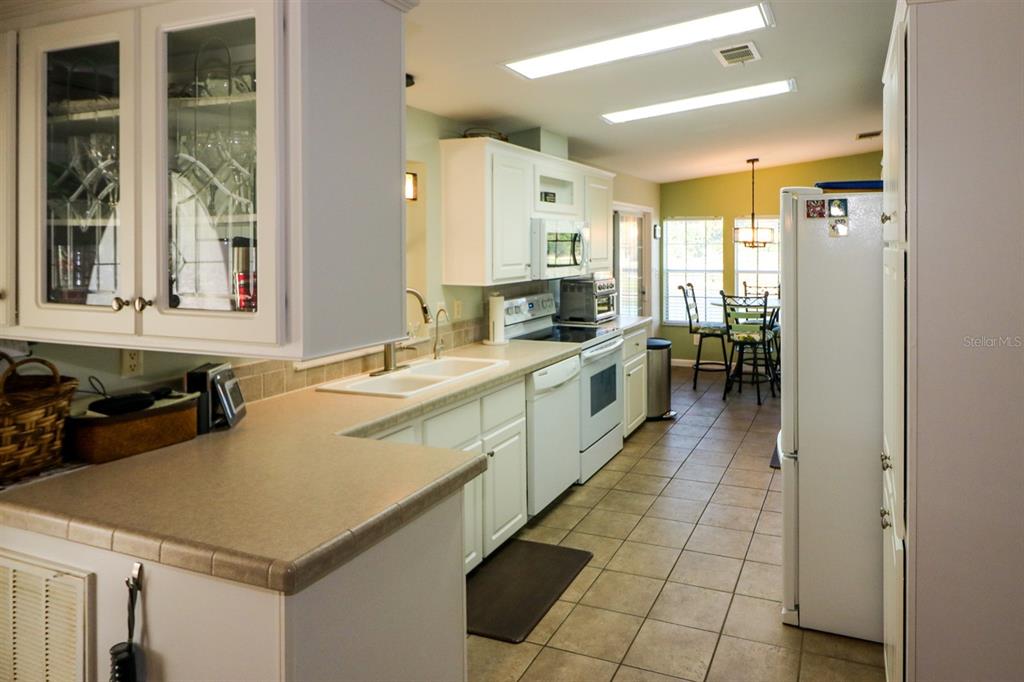 29200 South Jones Loop Road, Unit 522 Punta Gorda, FL 33950 - Photo 19 of 38 a large white kitchen with a window and stainless steel appliances