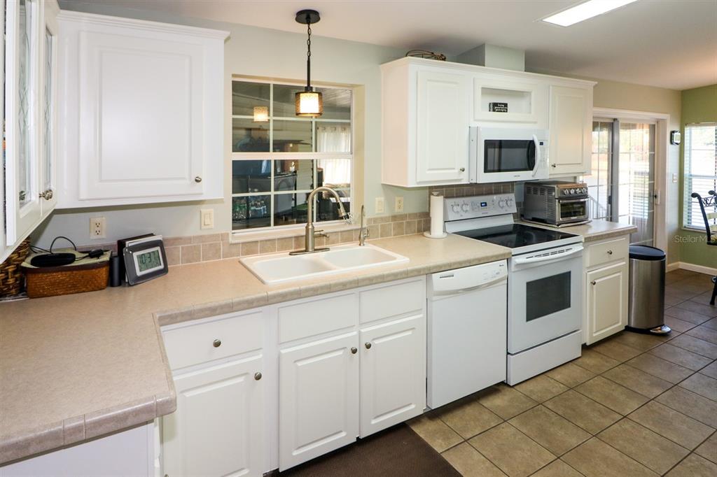 29200 South Jones Loop Road, Unit 522 Punta Gorda, FL 33950 - Photo 20 of 38 a kitchen with granite countertop white cabinets and white appliances