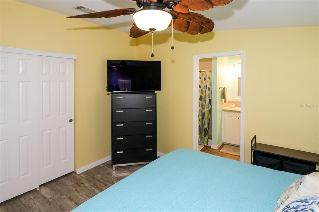 29200 South Jones Loop Road, Unit 522 Punta Gorda, FL 33950 - Photo 7 of 38 a bedroom with a bed and a chandelier