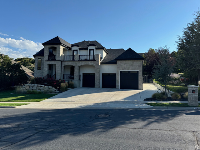 614 East High Lane Alpine, UT 84004 - Photo 6 of 75 French country home featuring stone siding, a balcony, stucco siding, concrete driveway, and a garage