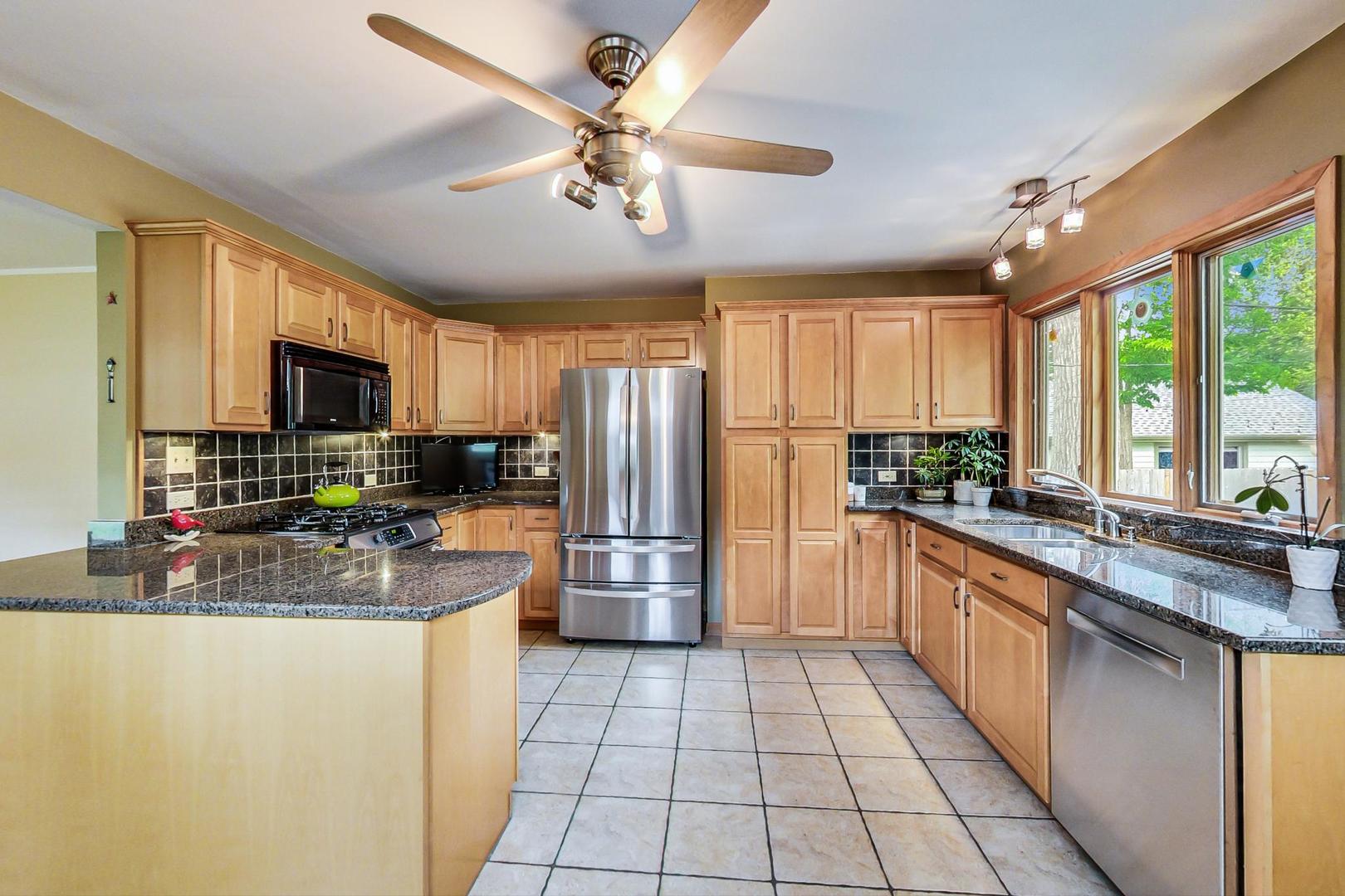 431 Selborne Road Riverside, IL 60546 - Photo 7 of 33 a kitchen with stainless steel appliances granite countertop a refrigerator a sink dishwasher a oven with a dining table and chairs