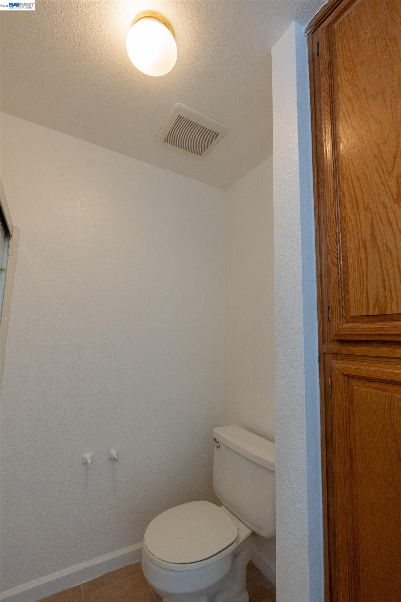 2932 Alcott Court Modesto, CA 95355 - Photo 14 of 39 a white toilet sitting next to a shower curtain