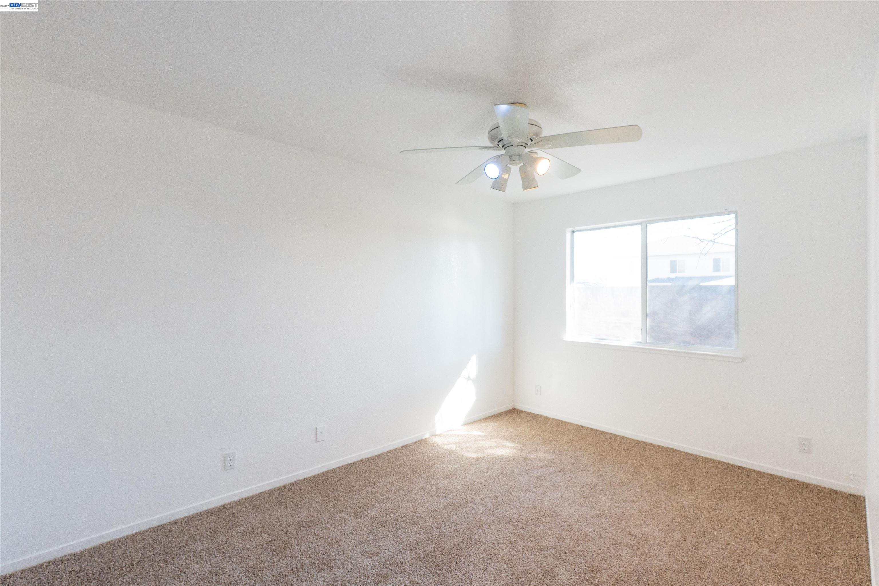 2932 Alcott Court Modesto, CA 95355 - Photo 25 of 39 an empty room with a window and a fan