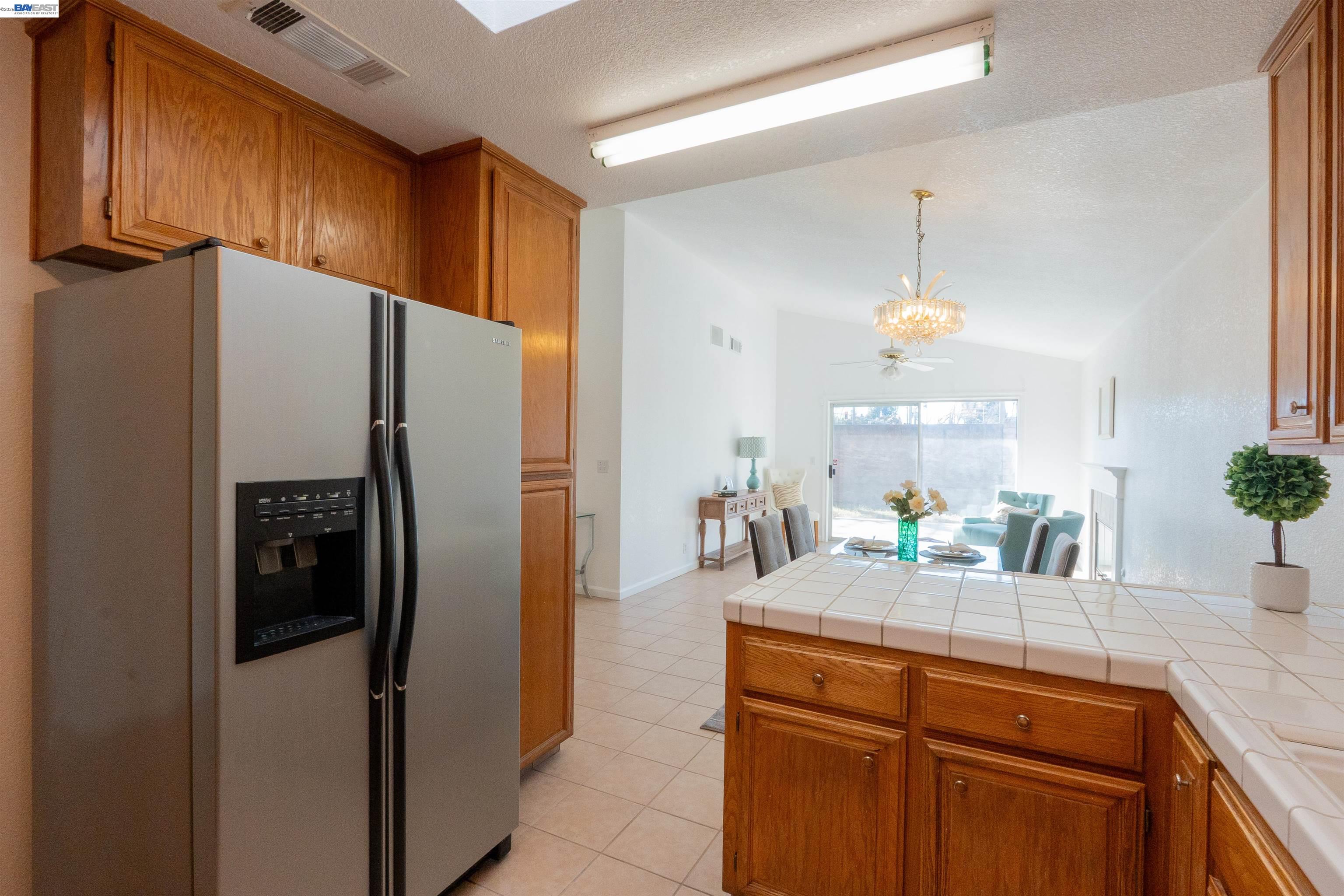 2932 Alcott Court Modesto, CA 95355 - Photo 27 of 39 a kitchen with stainless steel appliances a refrigerator a sink a counter space and cabinets