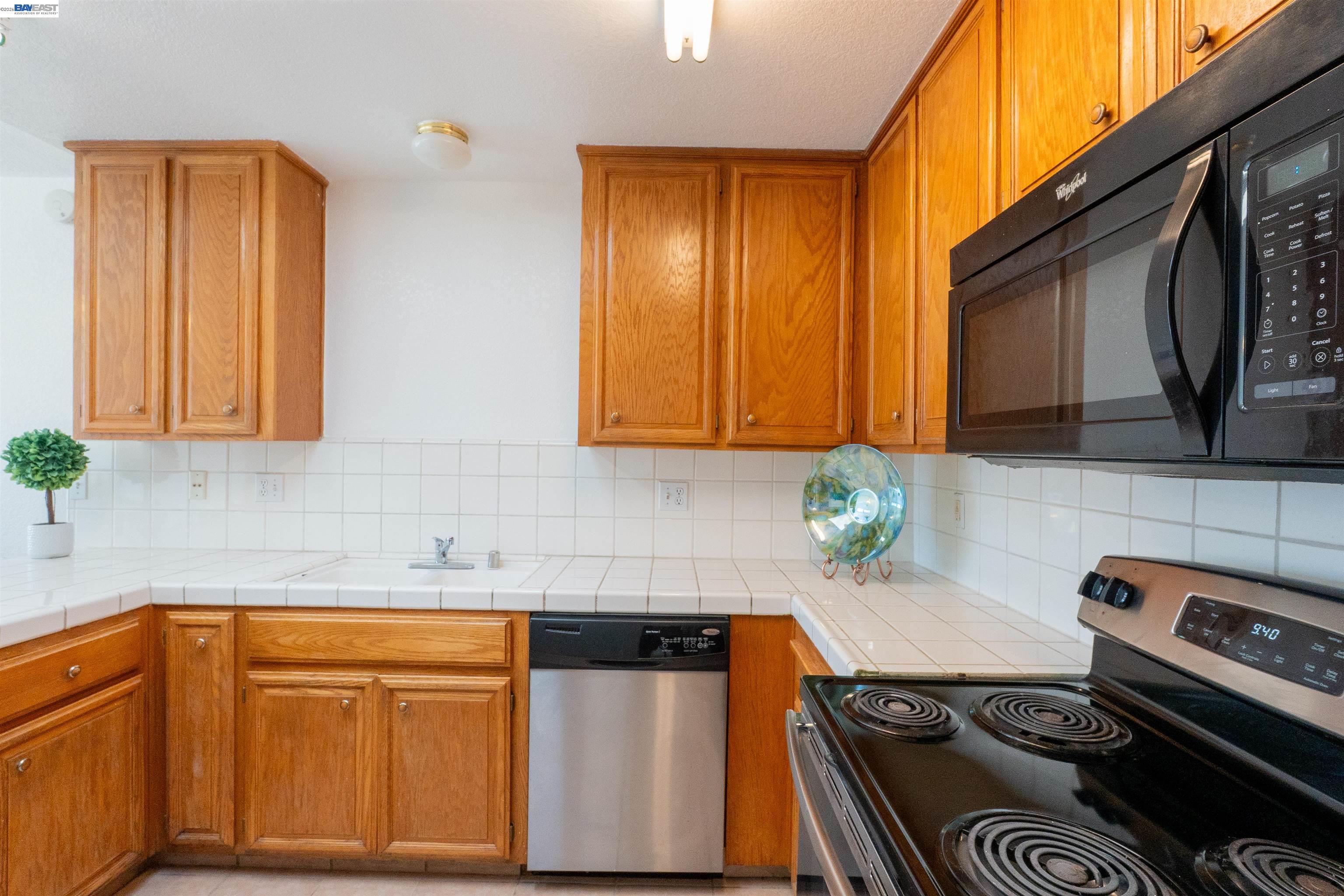 2932 Alcott Court Modesto, CA 95355 - Photo 28 of 39 a kitchen with stainless steel appliances granite countertop white cabinets and black stove top oven