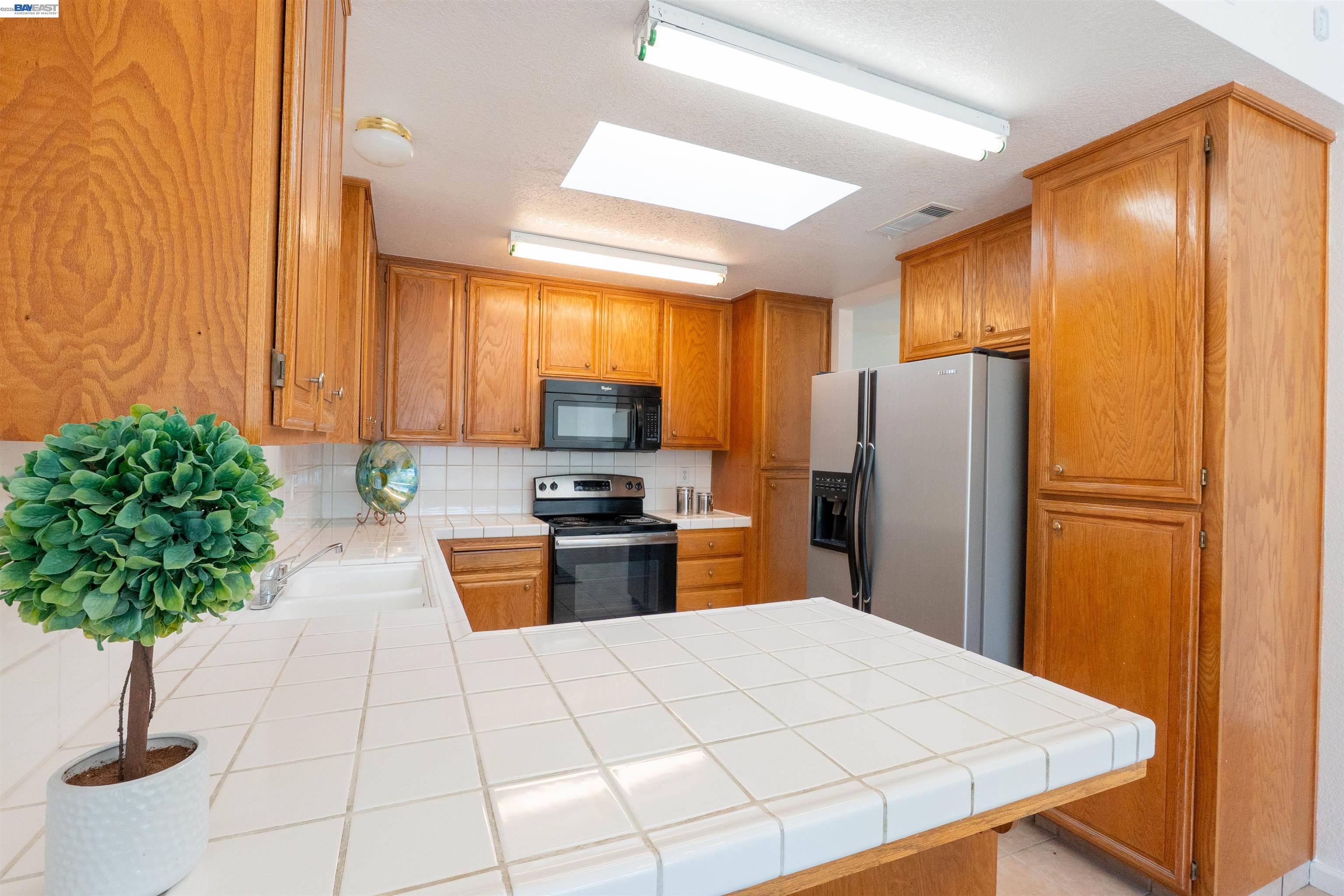 2932 Alcott Court Modesto, CA 95355 - Photo 30 of 39 a kitchen with stainless steel appliances a refrigerator sink and stove