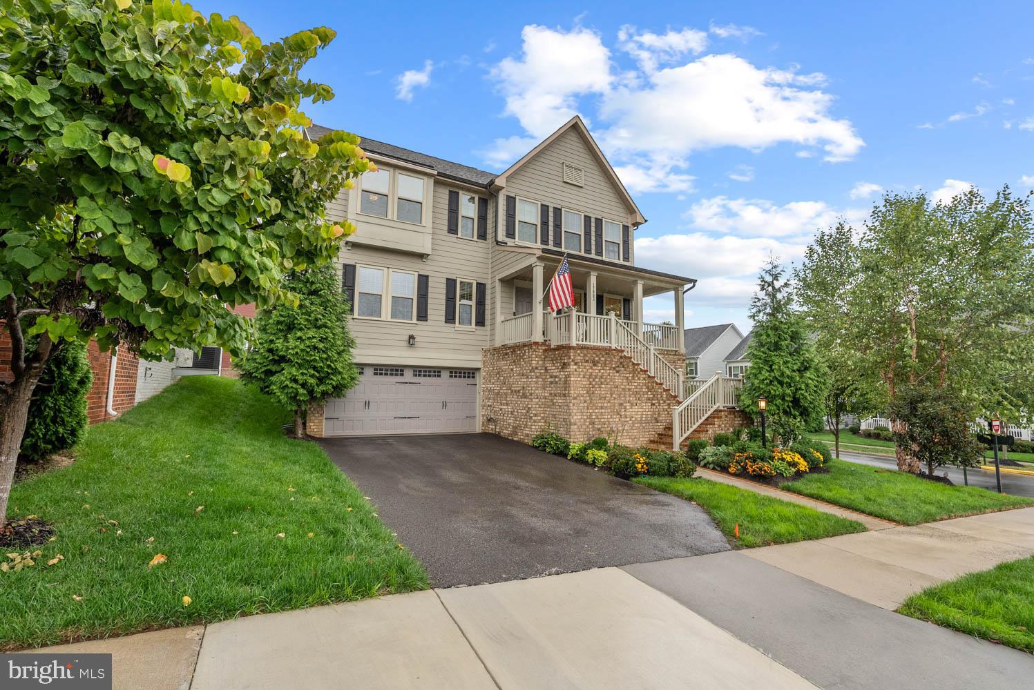 a front view of a house with a garden and trees