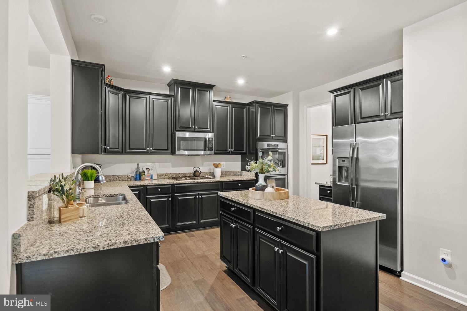 17883 Sugarberry Road Dumfries, VA 22026 - Photo 15 of 53 a kitchen with kitchen island granite countertop a sink stove and refrigerator