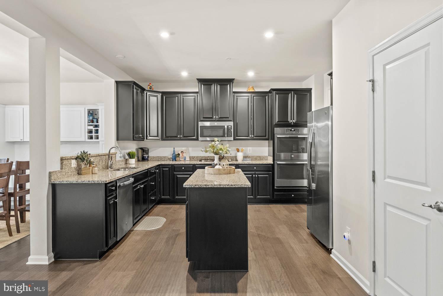 17883 Sugarberry Road Dumfries, VA 22026 - Photo 17 of 53 a kitchen with stainless steel appliances granite countertop a stove top oven a refrigerator and a sink