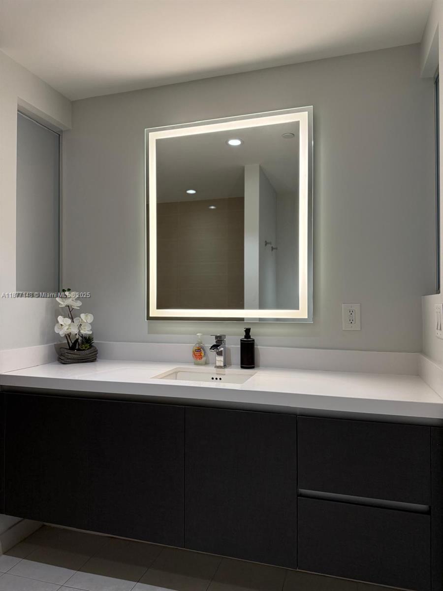 851 Northeast 1st Avenue, Unit 302 Miami, FL 33132 - Photo 17 of 30 a bathroom with a sink and a mirror
