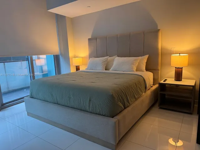 a large bed sitting in a bedroom next to a lamp