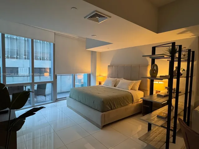 a bedroom with a large bed and a window