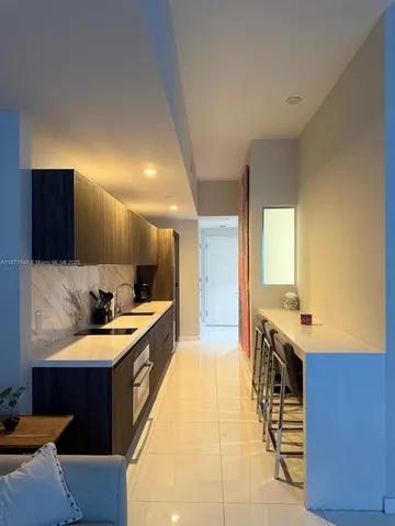 a large kitchen with a large counter top a sink a stove and a refrigerator