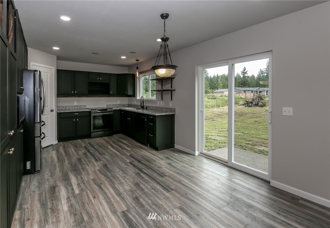 36313 Allen Road South Roy, WA 98580 - Photo 3 of 20 a kitchen with kitchen island a large counter top space appliances and a chandelier