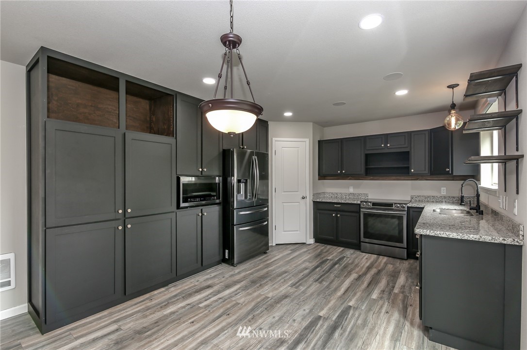 36313 Allen Road South Roy, WA 98580 - Photo 4 of 20 a kitchen with stainless steel appliances granite countertop a refrigerator a sink dishwasher a stove and a refrigerator