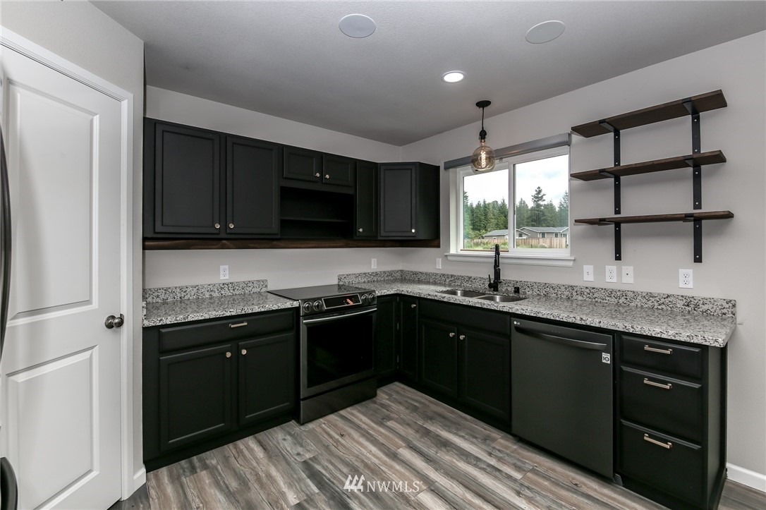 36313 Allen Road South Roy, WA 98580 - Photo 5 of 20 a kitchen with stainless steel appliances granite countertop a sink and stove top oven