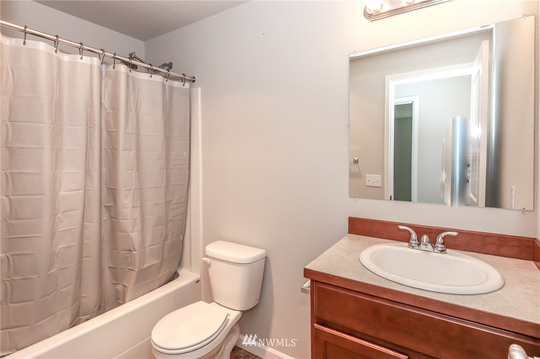 36313 Allen Road South Roy, WA 98580 - Photo 10 of 20 a bathroom with a sink a toilet a mirror and shower curtain