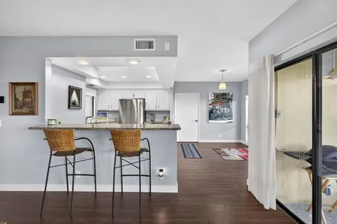 a living room with furniture and view of kitchen