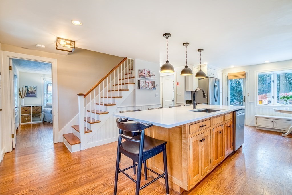 49 Jean Street Framingham, MA 01701 - Photo 6 of 41 a view of a kitchen with kitchen island granite countertop wooden floor and a view of living room