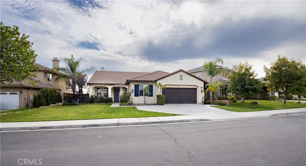 front view of house with a yard and trees around