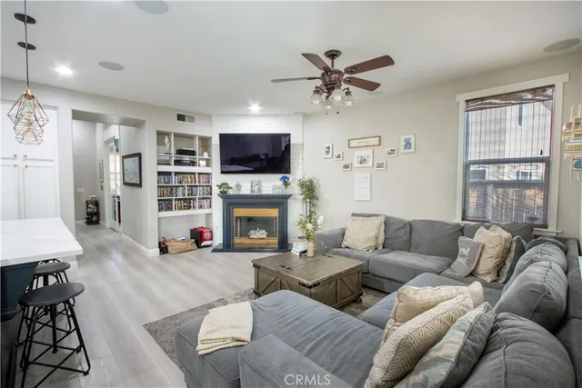 a living room with furniture a flat screen tv and a fireplace