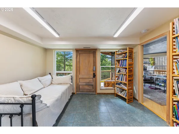 a living room with furniture a flat screen tv and a floor to ceiling window
