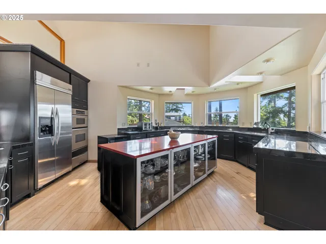 a kitchen with stainless steel appliances granite countertop a sink a stove and a refrigerator