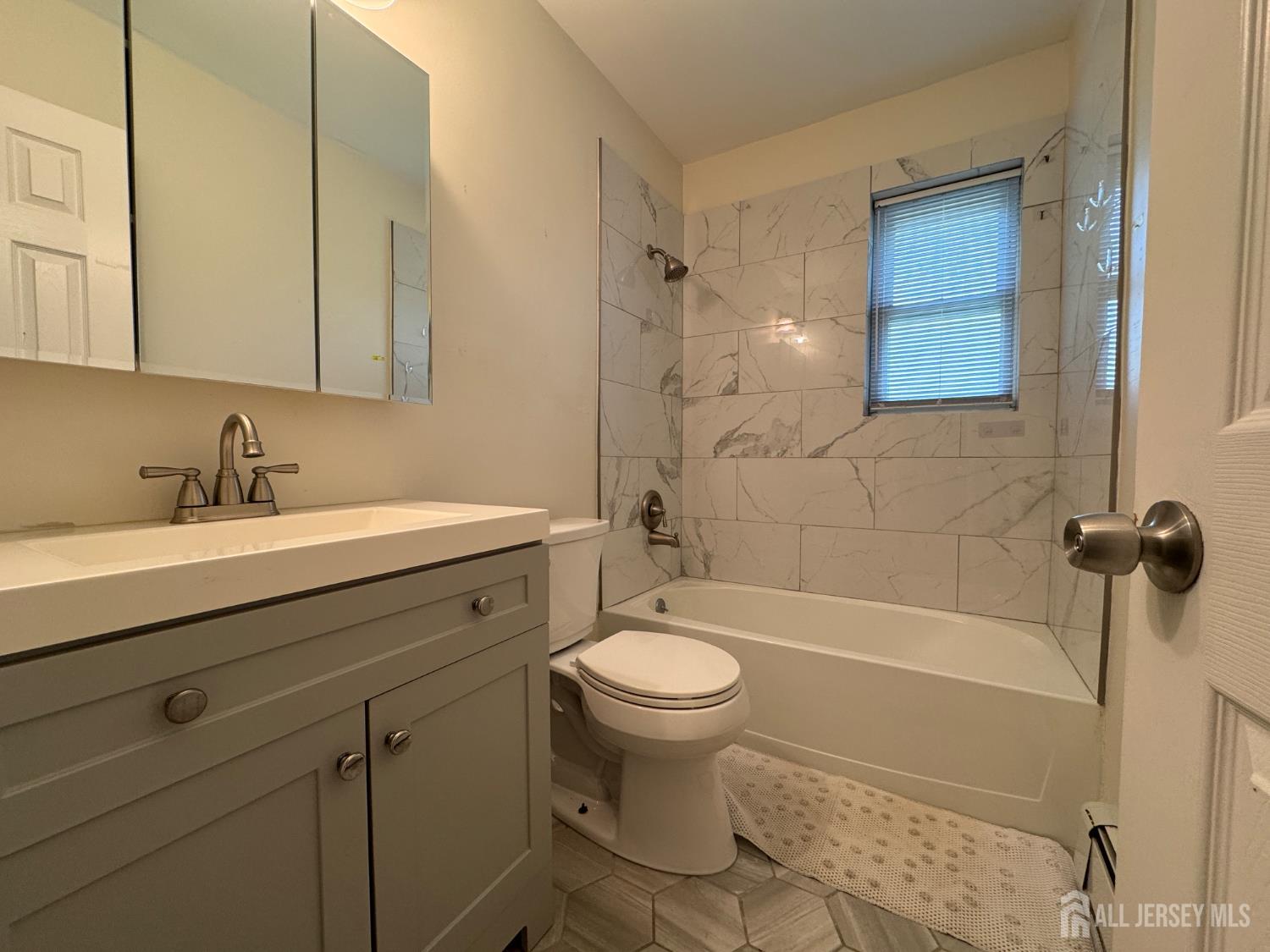 289 Main Street, Unit 6E Spotswood, NJ 08884 - Photo 9 of 16 a bathroom with a sink a toilet and shower