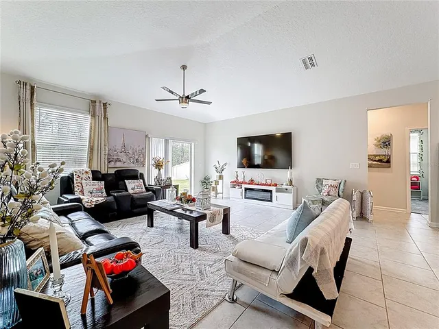 a living room with furniture a flat screen tv and a window