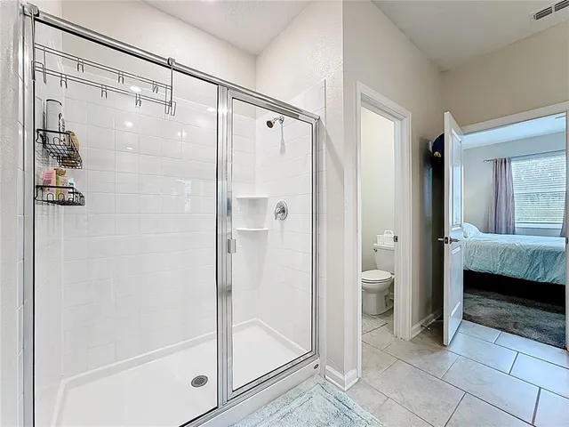 a bathroom with a glass shower door and a sink