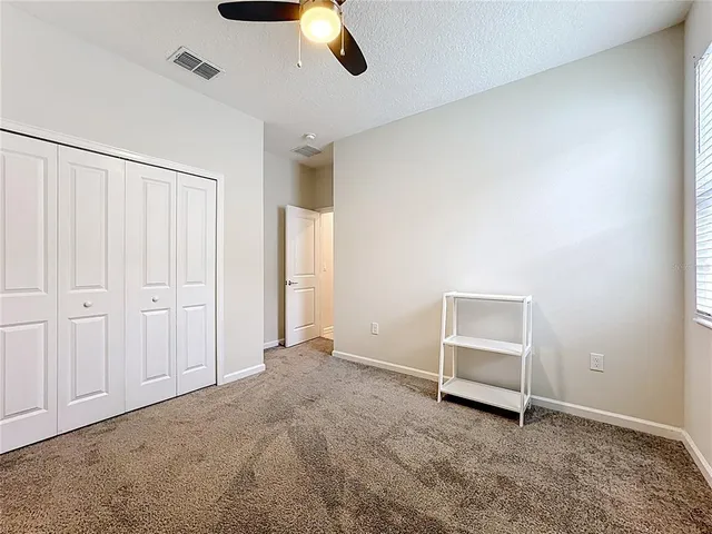 an empty room with closet and windows