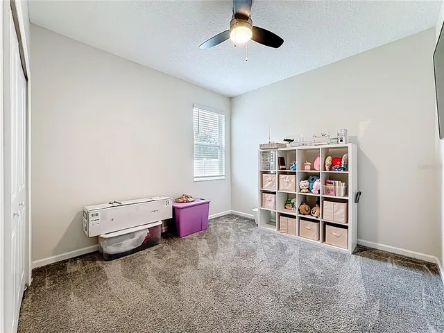 a view of a bedroom with baby crib and cabinet