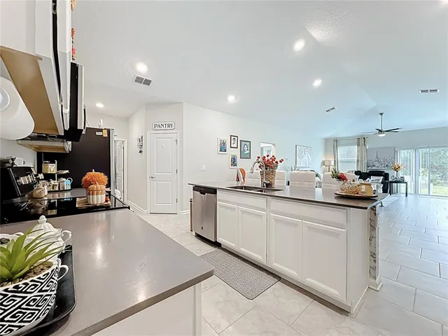 a kitchen with sink cabinets and living room view