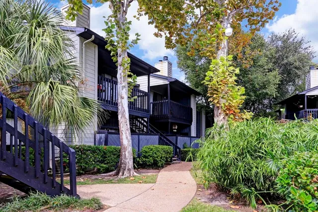 a front view of a house with plants and trees