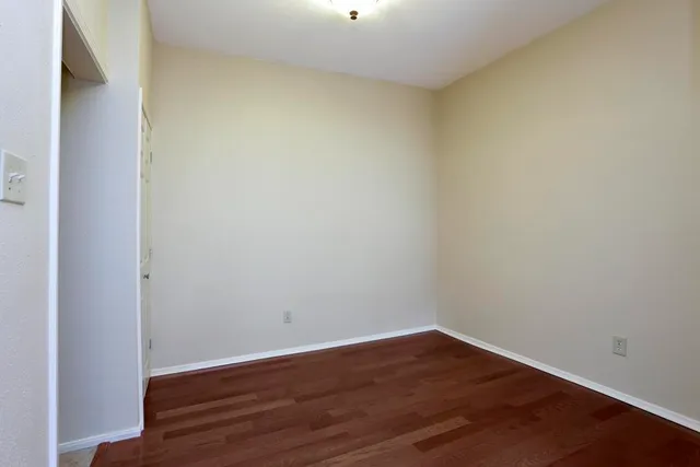 a view of an empty room with wooden floor