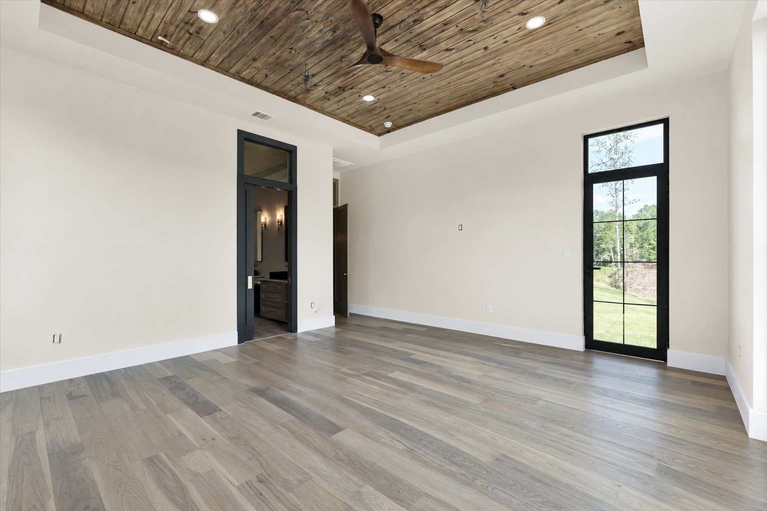 23701 Birch Grove Road Montgomery, TX 77316 - Photo 19 of 50 Experience serene elegance in the main bedroom, featuring a stunning picture window that invites an abundance of natural light and offers picturesque views.