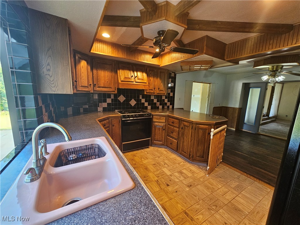 1325 Ohltown McDonald Road Mineral Ridge, OH 44440 - Photo 11 of 33 Kitchen with ceiling fan, decorative backsplash, sink, and stove