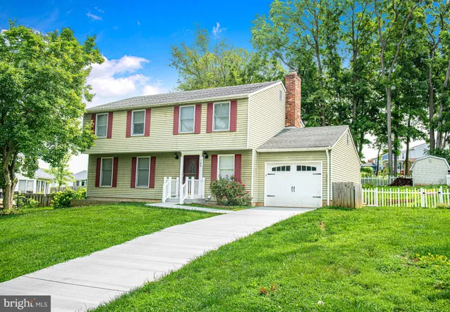 a front view of a house with a yard and trees
