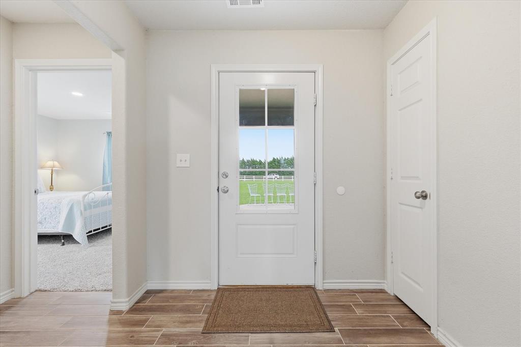 110 Highview Road Ennis, TX 75119 - Photo 6 of 40 Entryway featuring wood-finish tile flooring, a white paneled door with a half-lite window, and a crisp white wall palette