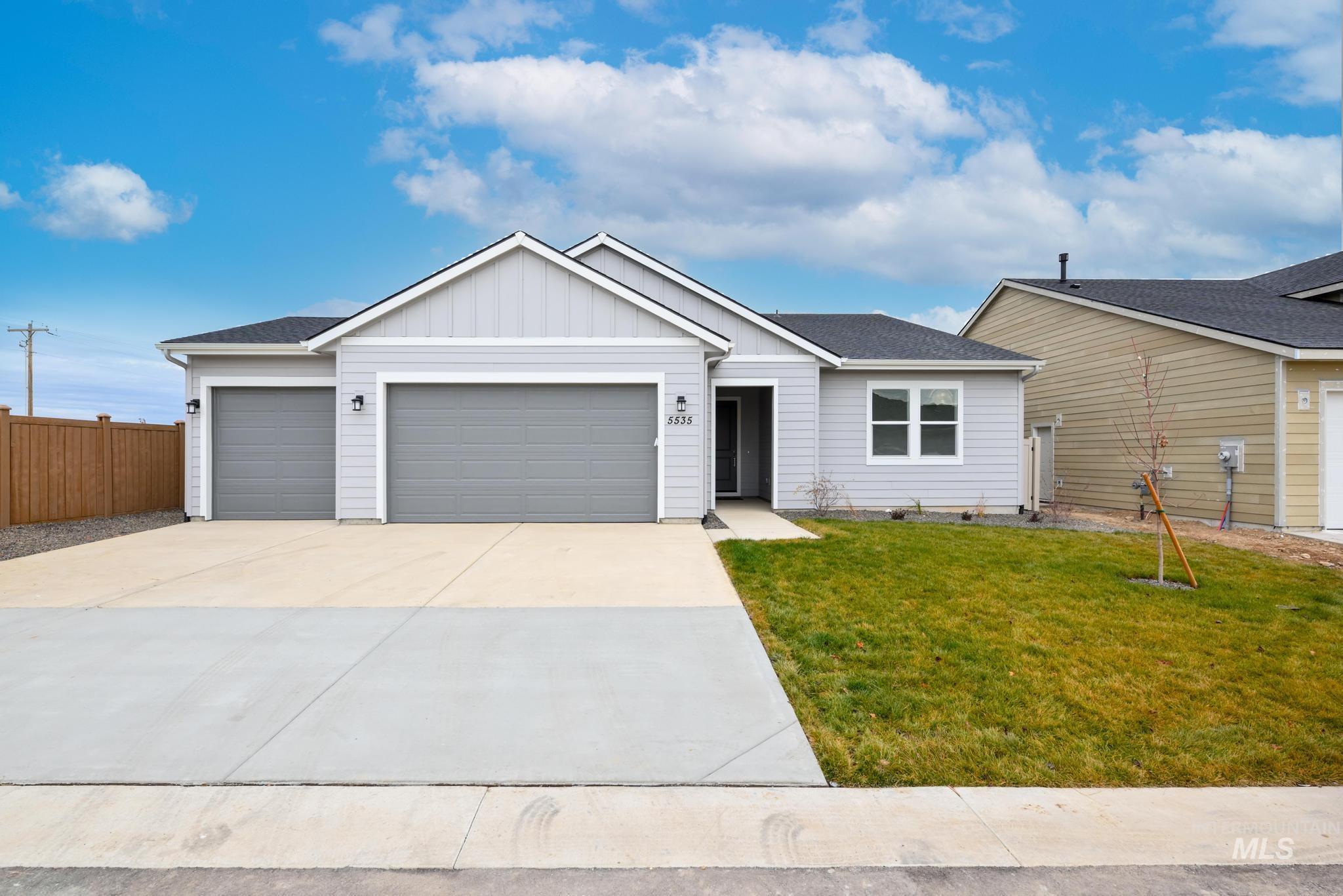 Ranch-style house with an attached garage, board and batten siding, roof with shingles, and concrete driveway