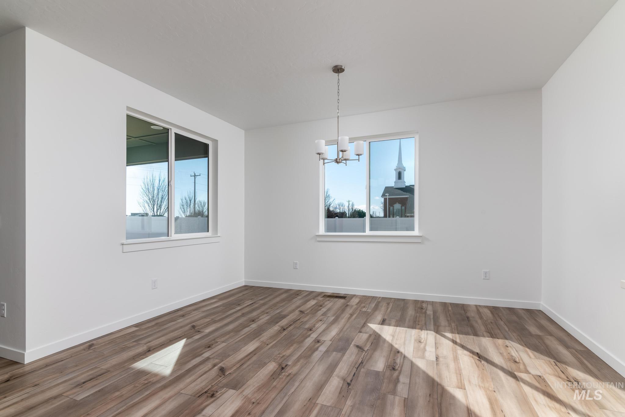 893 West Bay Street Middleton, ID 83644 - Photo 6 of 10 Unfurnished dining area featuring plenty of natural light, hanging lights, and wood finished floors