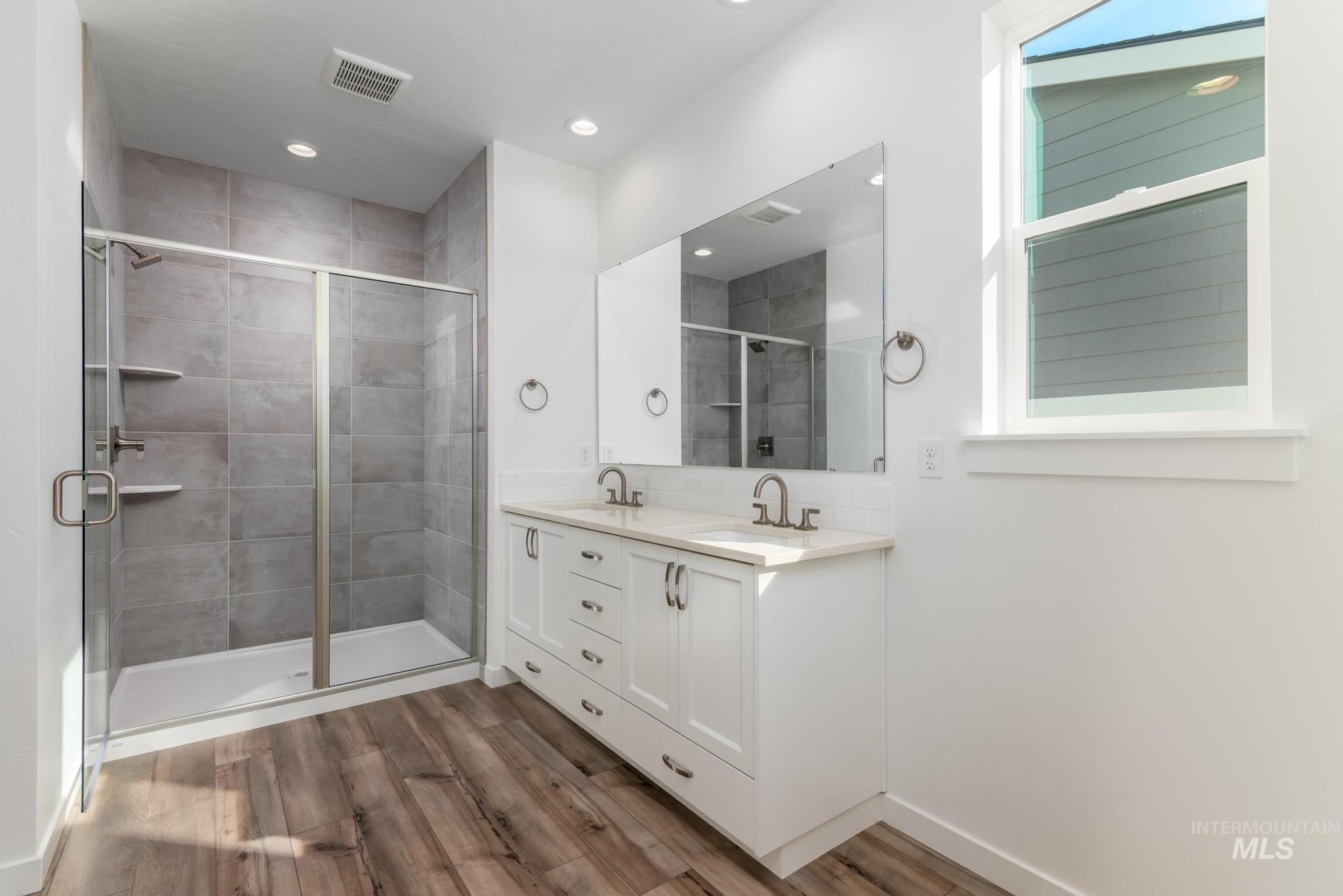893 West Bay Street Middleton, ID 83644 - Photo 9 of 10 Full bath with double vanity, a stall shower, dark wood finished floors, and recessed lighting