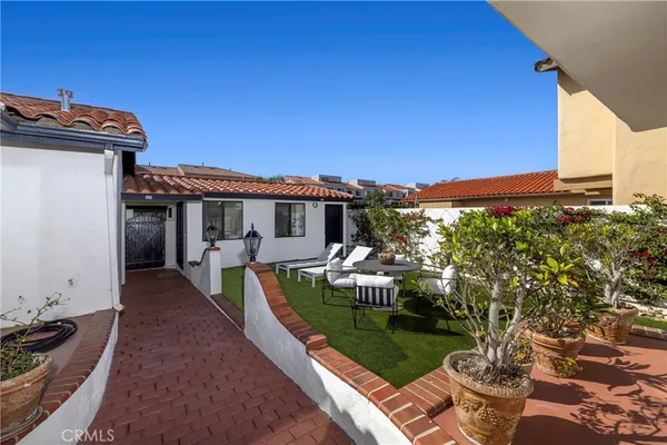 a view of a patio with couches table and chairs under an umbrella
