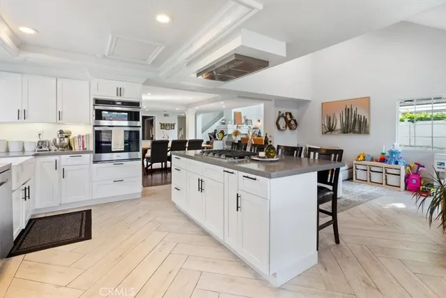 a kitchen with stainless steel appliances kitchen island granite countertop a stove a sink and a refrigerator