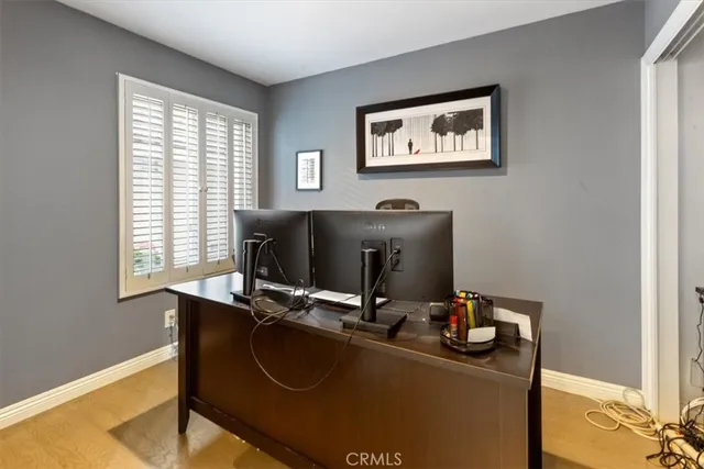 a view of a workspace with furniture and a window