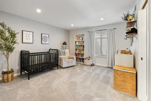 a view of a bedroom with baby crib and furniture