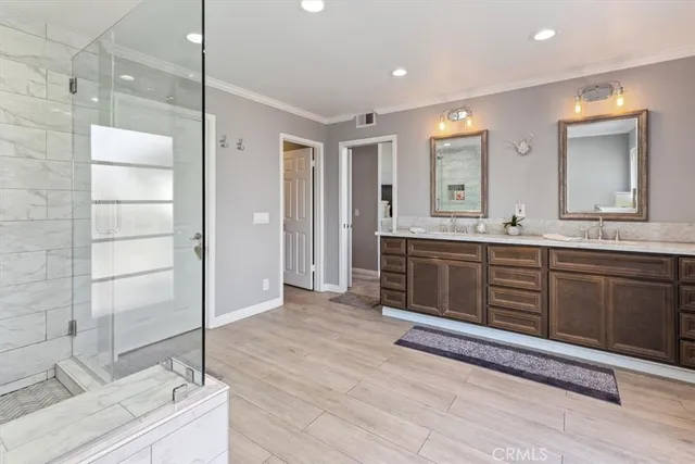 a bathroom with a double vanity sink a large mirror and a shower