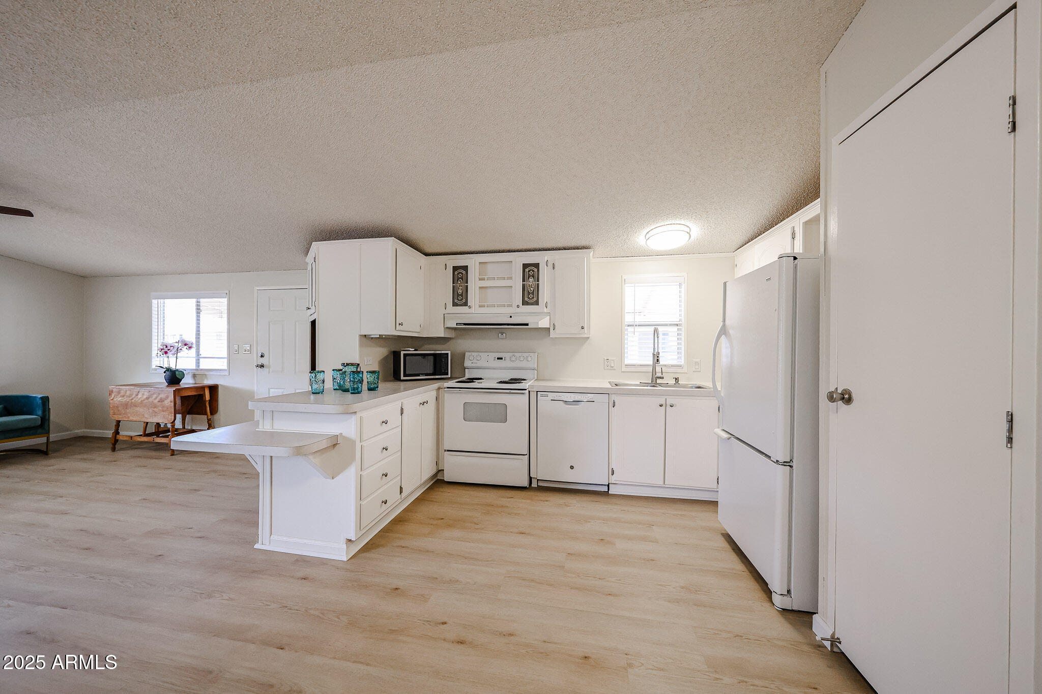 3901 East Pinnacle Peak Road, Unit 36 Phoenix, AZ 85050 - Photo 9 of 26 a kitchen with white cabinets and white appliances