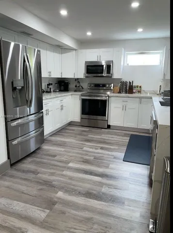 a kitchen with granite countertop a refrigerator stove and microwave